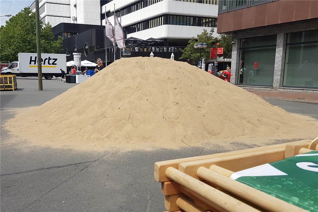 Ein riesiger Sandhaufen in der Innenstadt - dahinter steckt eine Party Das Rätselraten um den riesigen Sandhaufen in der Innenstadt hat ein Ende.