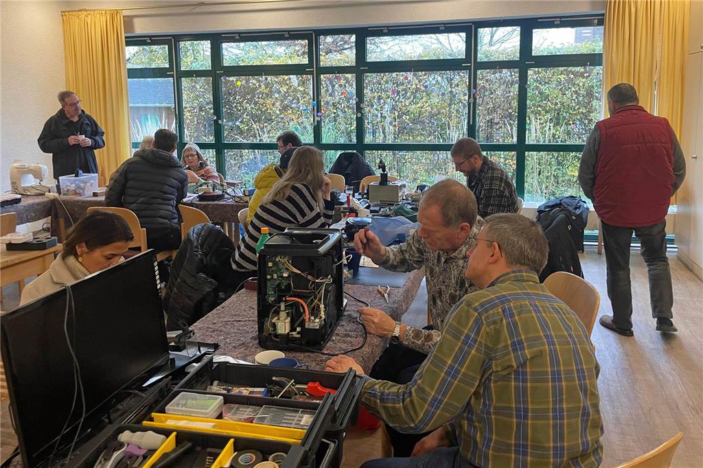 Helfer arbeiten im Repair-Café von Werne an einem Elektrogerät. 