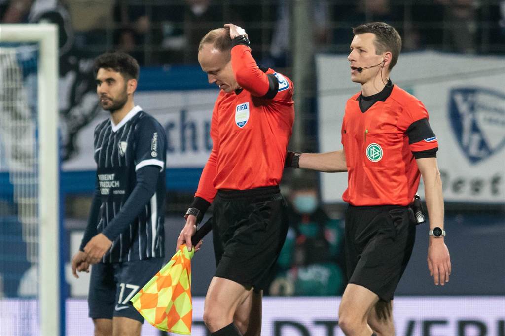 Linienrichter nach Bierbecherwurf beim VfL Bochum: „Wichtig, dass das nicht unbestraft bleibt“ Das Schiedsrichtergespann um Benjamin Cortuns (r) verlässt während der Partie zwischen dem VfL Bochum und Borussia Mönchengladbach das Spielfeld, nachdem Schiedsrichterassistent Christian Gittelmann (2.v.r.) einen Becher an den Kopf bekommen hatte.