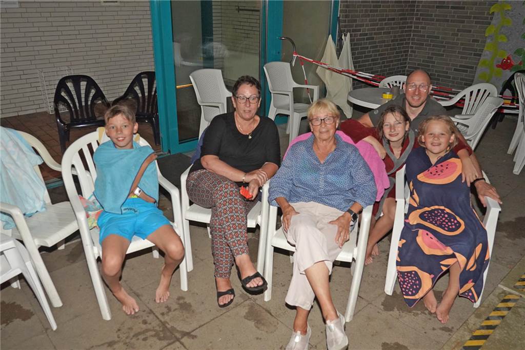 Fotos vom Nachtschwimmen 2024 im Freibad Castrop-Rauxel bei Regen. Besucher schwimmen unter freiem Himmel bei Fackelschein am Abend. Entspannte Atmosphäre und kulinarisches Angebot. 
