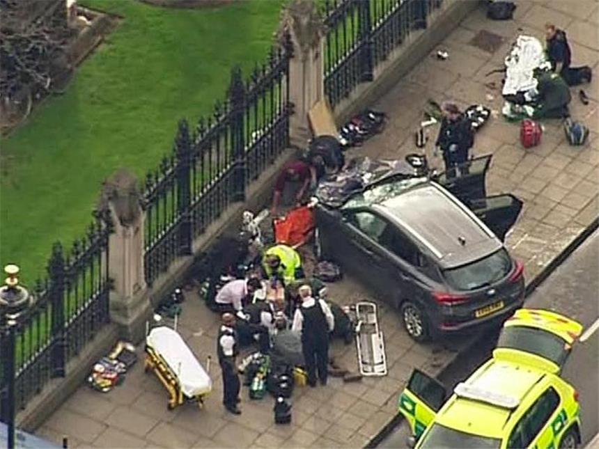 IS bekennt sich zu Londoner Anschlag Das Standbild aus einem Video zeigt Hilfskräfte, die in der Nähe des britischen Parlaments neben einem Auto einen Verletzten behandeln. Foto: ITN via APTN/AP
