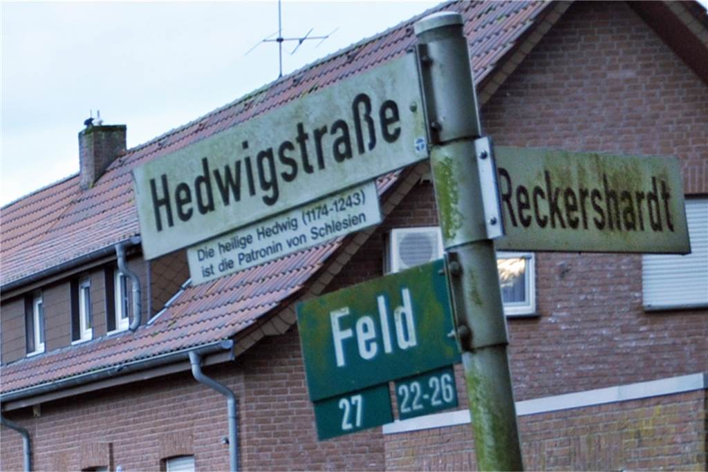 Das Straßenschild zeigt war keine Gemeinden an, aber hier liegen Oedinger und Burloer Haushalte an einem Straßenzug. Die Burloer haben die Adresse Hedwigstraße, die oeinger wohnen in der Bauerschaft Feld.