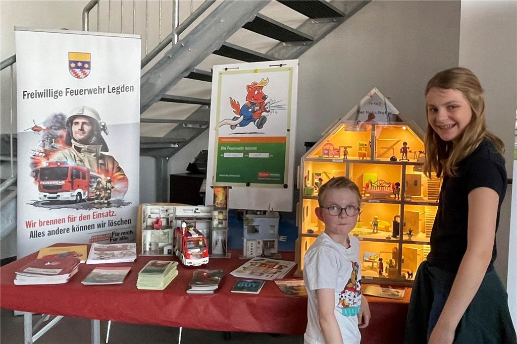 Zwei Kinder stehen vor einem Tisch mit Infomaterial.