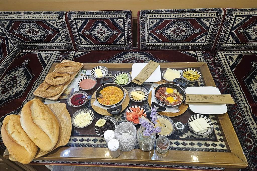 Bunt gemischtes Frühstück mit heißer Pfanne, Beilagen und Brot.