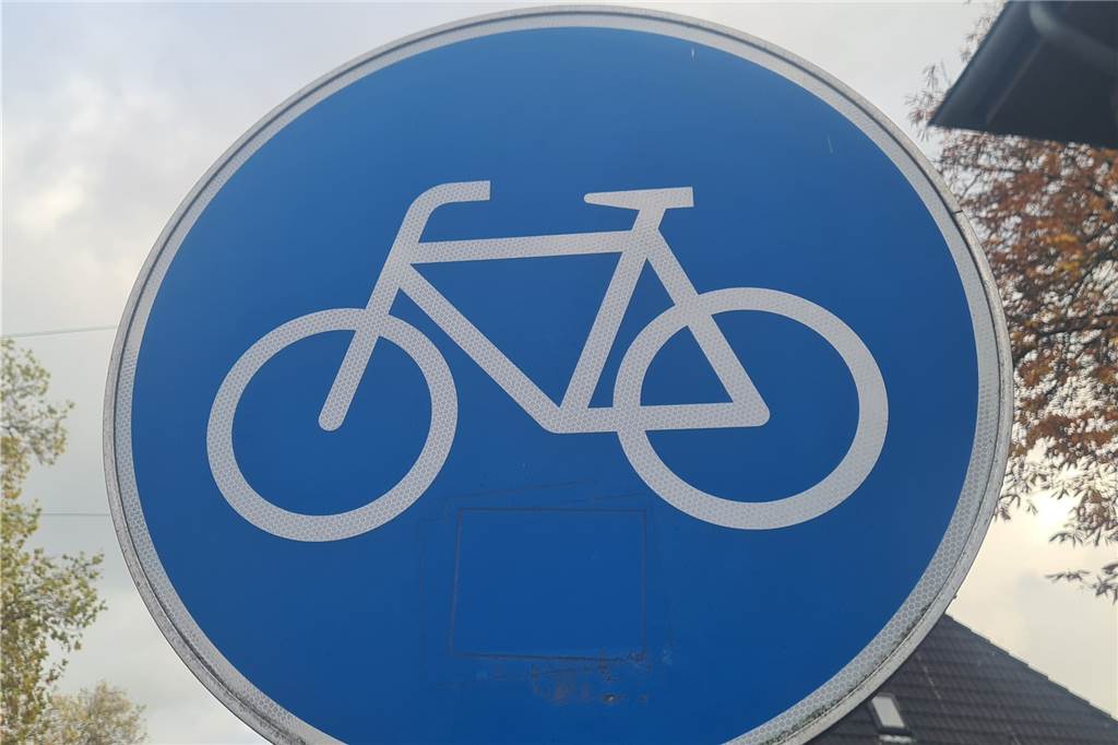 Das Verkehrszeichen für den Radfahrstreifen. Radfahrer müssen ihn benutzen. Autos dürfen hier nicht fahren, halten oder parken.