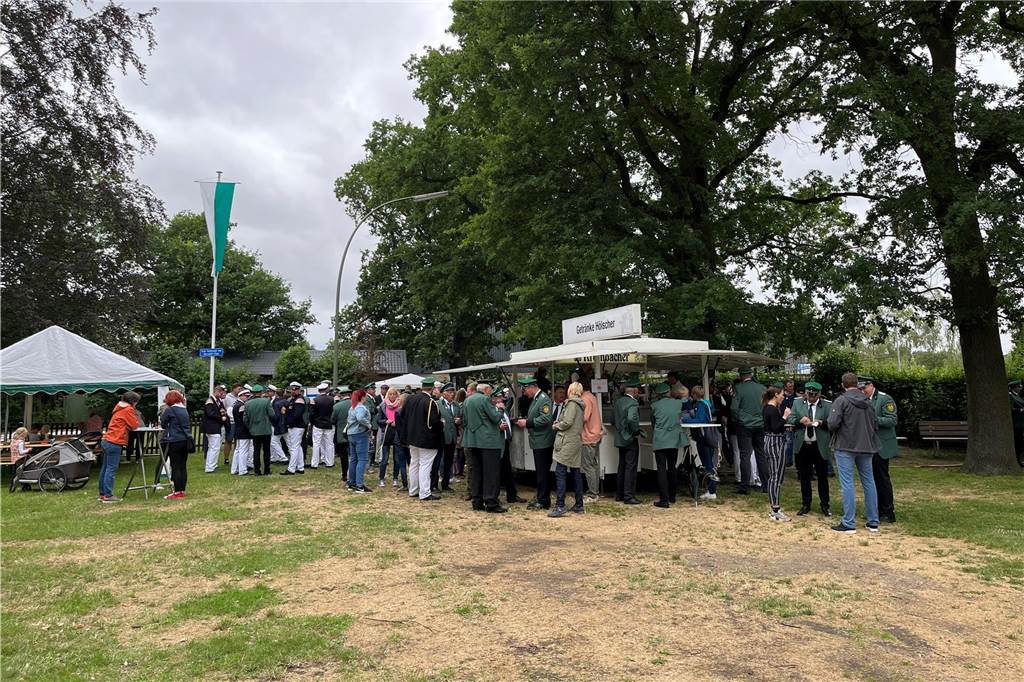 Ein Blick auf die Grünfläche. Viele Menschen standen zusammen, lachten und unterhielten sich. 