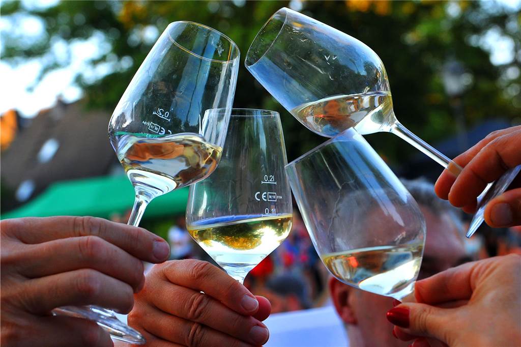 Das vierte Weinfest am Wuckenhof: Alle wichtigen Infos zum Genussfest Zu sehen ist ein Eindruck des letzten Weinfestes, genauer gesagt vier Weingläser, die hochgehalten werden.