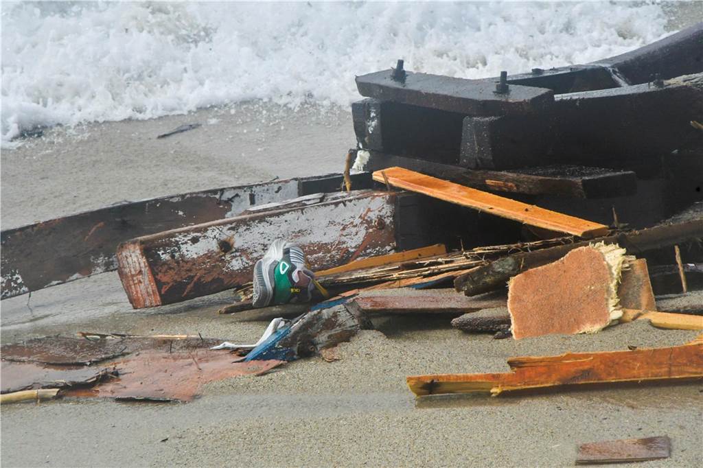 Mindestens 43 Migranten tot nach Bootsunglück vor Süditalien Wrackteile liegen an der Küste an Strand.