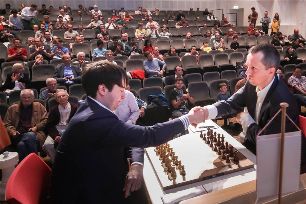 Von „spanischen Eröffnungen“ und „kriminellen Zügen“: Das Chess-Meeting ist eröffnet Das Zuschauerinteresse an den Schachpartien im Saal des Orchesterzentrums ist groß. Hier geben sich Teimour Radjabov und Radoslaw Wojtaszek zu Beginn die Hand.