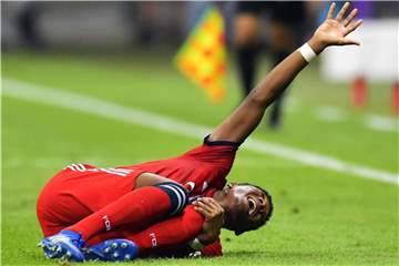 David Alaba liegt verletzt an der Seitenlinie und hebt den Arm. Foto: Uwe Anspach