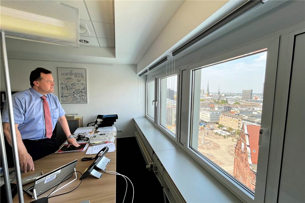Dem Friedensplatz so nah: Norbert Dahmen genießt für das Foto die Sicht von seinem Schreibtisch. Im Alltag nimmt er den Ausblick oft nicht wahr.