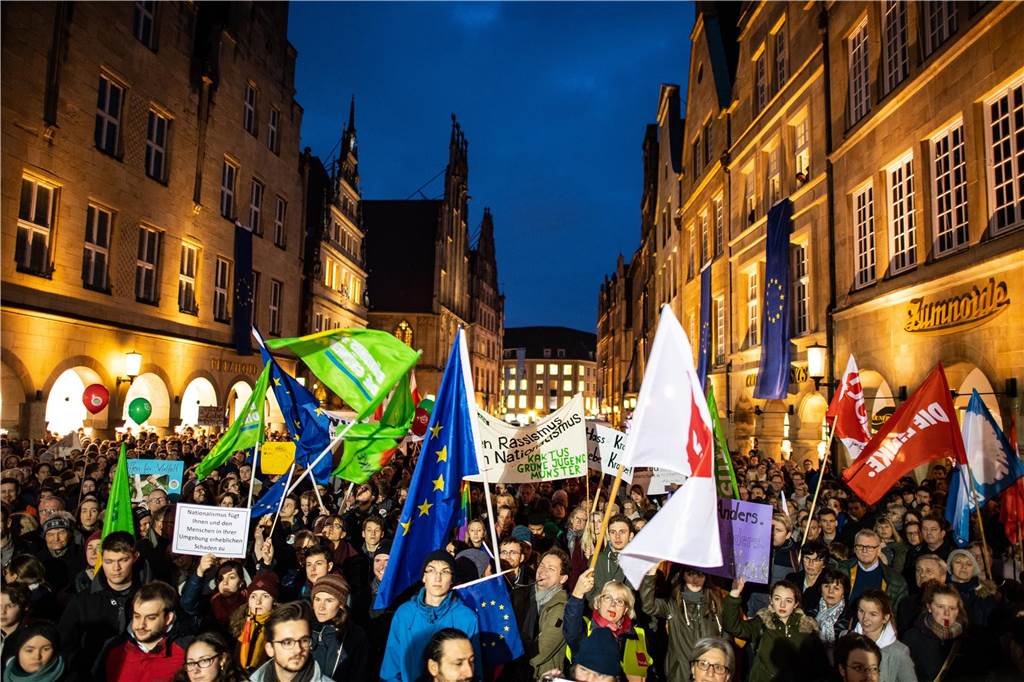 Polizei Münster rüstet sich für AfD-Neujahrsempfang: Tausende Demonstranten erwartet Demonstranten stehen vor der Bühne am Historischen Rathaus auf dem Prinzipalmarkt.