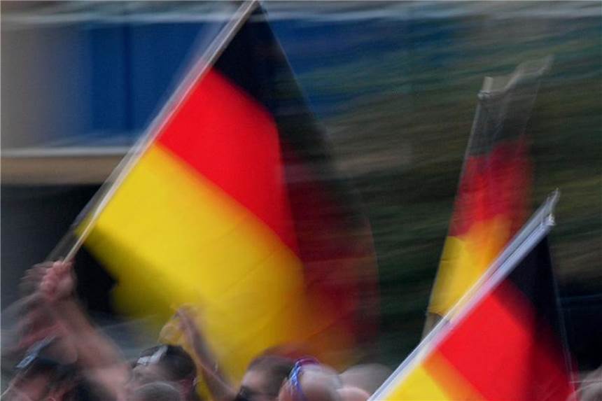 Demonstranten tragen bei einem Protestzug deutsche Flaggen. Ein Jahr nach der Bundestagswahl gibt es viel Anlass für Verunsicherung in Deutschland. Foto: Hendrik Schmidt