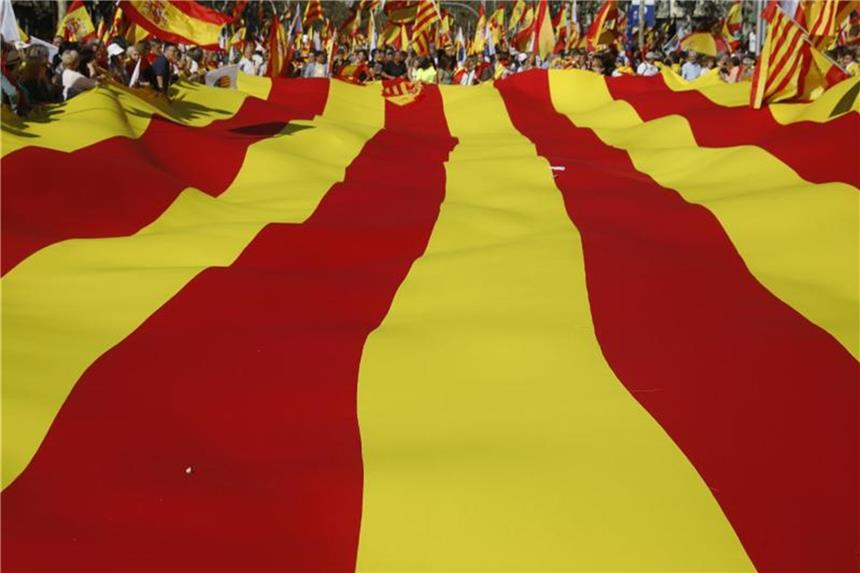 Deutsche Firmen bei Investitionen in Katalonien kritischer Demonstranten tragen eine riesige katalanische Flagge durch Barcelona. Im wirtschaftsstarken Katalonien machen viele deutsche Unternehmen Geschäfte. Foto: Santi Palacios