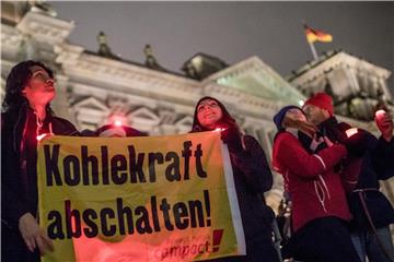 Demonstranten verschiedener Organisationen stehen in Berlin und fordern die Verhandler bei den Sondierungsgesprächen zu einem Kohleausstieg auf. Foto: Michael Kappeler