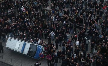 Demonstranten werfen in Köln ein Polizeiauto um.