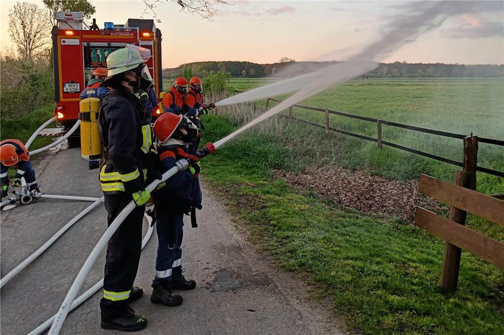 Jugendliche entdecken Feuerwehr-Alltag mit simulierten Einsätzen Junge Feuerwehrleute löschen einen Brand