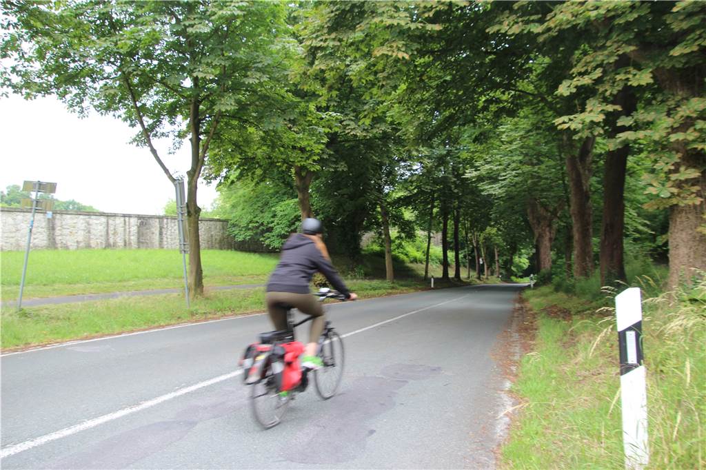 Radweg mit Treppe: Wann endet Gefahrenstelle vor Schloss Cappenberg? Den Schlossberg hinab geht es für Radfahrer über die Straße. Die in die Jahre gekommene Fahrbahn weist zahlreiche Abplatzungen und Rillen auf.
