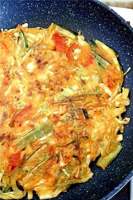Pfannekuchen ganz anders: Probieren Sie mal die koreanische Variante Der koreanische Pfannekuchen wird in einer Pfanne ausgebacken.