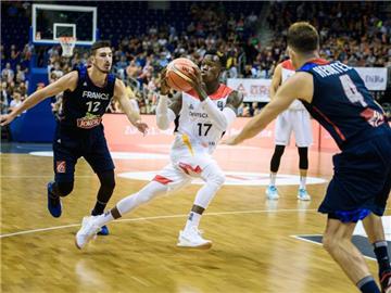 Dennis Schröder (M) zieht gegen die Franzosen Nando De Colo und Thomas Heurtel (r) zum Korb. Foto: Gregor Fischer
