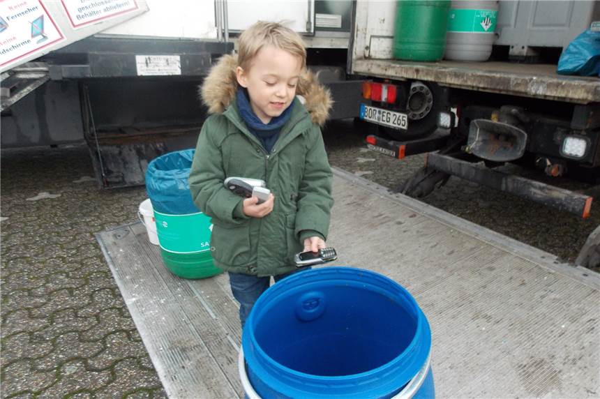 Bei Sammelaktion landen in Heek 30 alte Handys und Smartphones in der Tonne Der 5-jährige Paul Rottmann wirft die alten Handys seiner Eltern in die blaue Tonne des Schadstoffmobils.