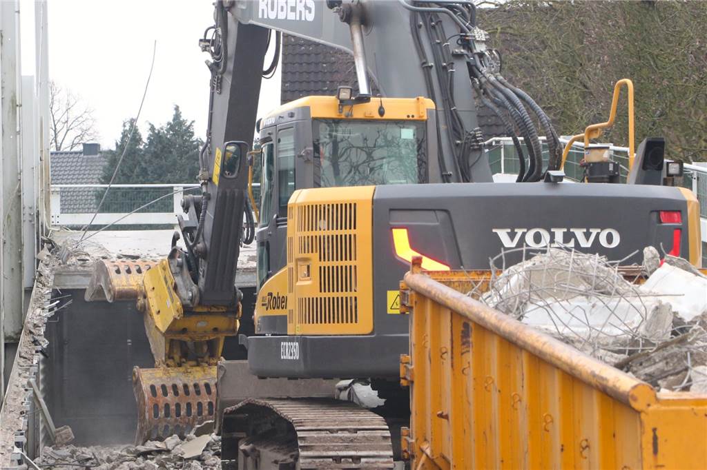 Nächste Großbaustelle: Abbruch des Parkdecks am ehemaligen Krankenhaus gestartet ein Container steht hinter einem Bagger