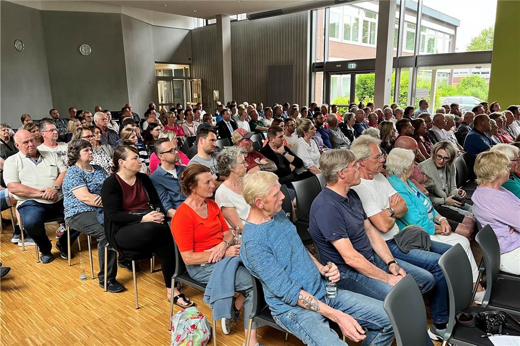 Menschen sitzen in der Aula in Herbern.