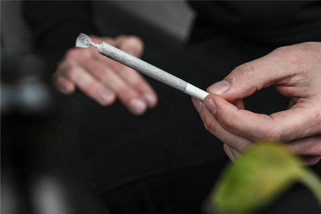 Körperverletzung und Drogenbesitz: Mann aus Werne (27) steht vor Gericht Eine Hand hält einen gedrehten Joint.