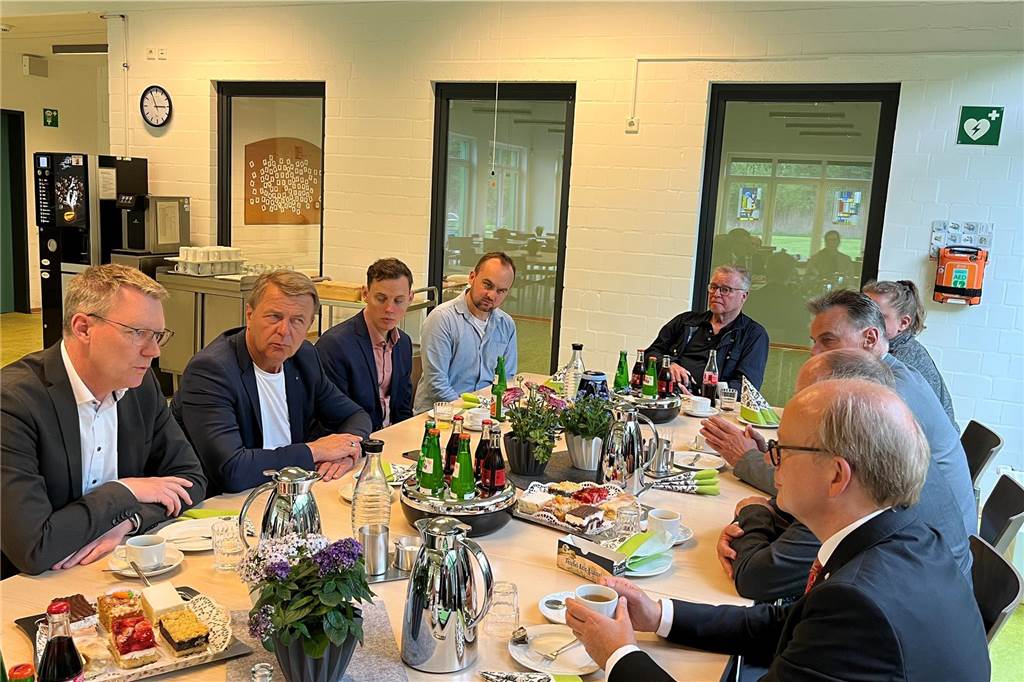 Mitarbeiter der Caritas und die Politiker aus dem Landtag im Gespräch bei Kaffee und Kuchen.