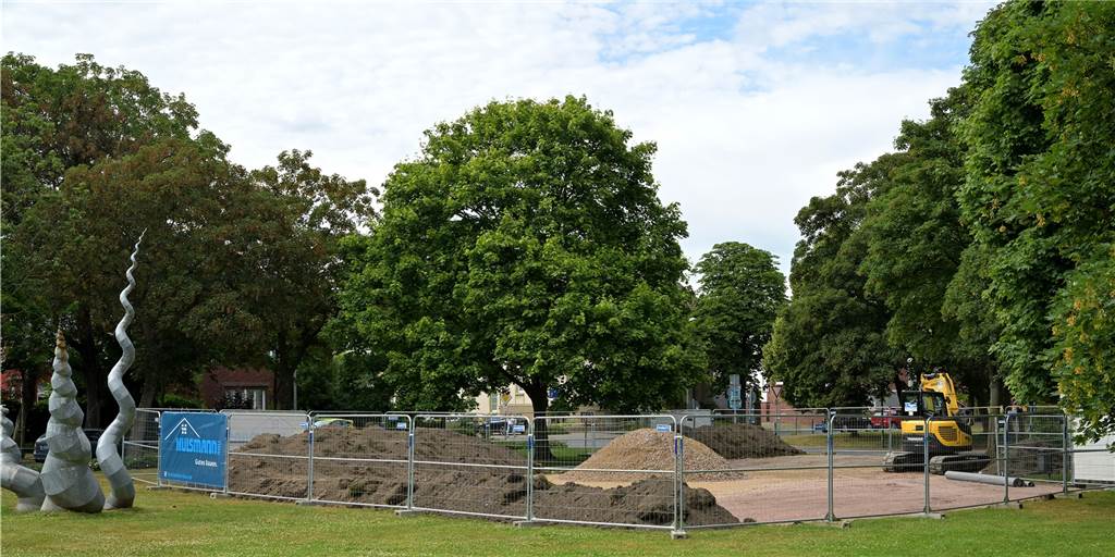 Baustelle in Lünens Innenstadt: Dass nicht gearbeitet wird, ist gewollt Der Bauzaun reicht inzwischen bis ans Kunstwerk auf der grünen Freifläche Gartenstraße/Grad-Adolf-Straße in Lünen. Was passiert dahinter?