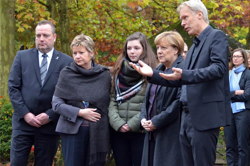 Angela Merke schreibt zum Jahrestag: „Ein Zusammenhalt, der hilft“ Bundeskanzlerin Angela Merkel mit Bürgermeister Bodo Klimpel, Vize-Ministerpräsidentin Sylvia Löhrmann, Schülersprecherin Johanna König und Schulleiter Ulrich Wessel bei ihrem Besuch nach dem Germanwings-Absturz am Joseph-König-Gymnasium in Haltern.