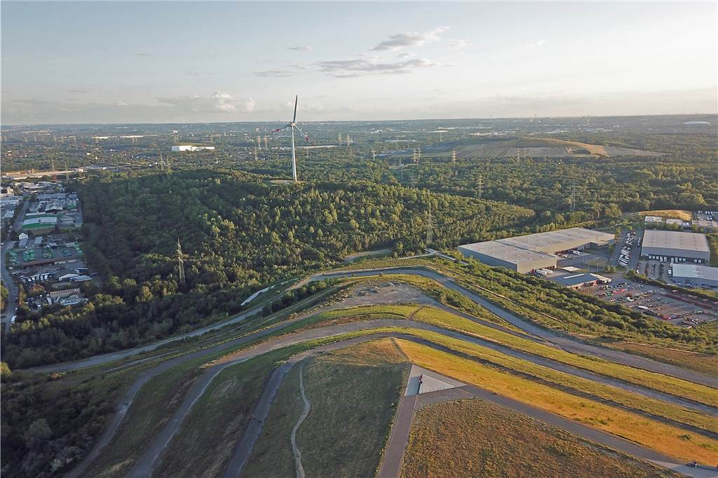 Der perfekte Aussichtspunkt übers grüne Ruhrgebiet: Halde Hoheward Der Blick vom Plateau-Rand im Westen fällt über die benachbarte Halde Hoppenbruch mit der Windkraftanlage bis nach Essen und zur Schalke-Arena. Manchmal erkennt man am Horizont auch den Düsseldorfer Rheinturm.