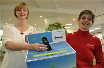 Der BUND stellt in der Stadtbibliothek Selms erste Recyclingstation für Althandys auf. Margit Breiderhoff (r.), Leiterin der Stadtbibliothek, und Silvia Lippert vom BUND präsentieren den Pappkarton mit der Öffnung.