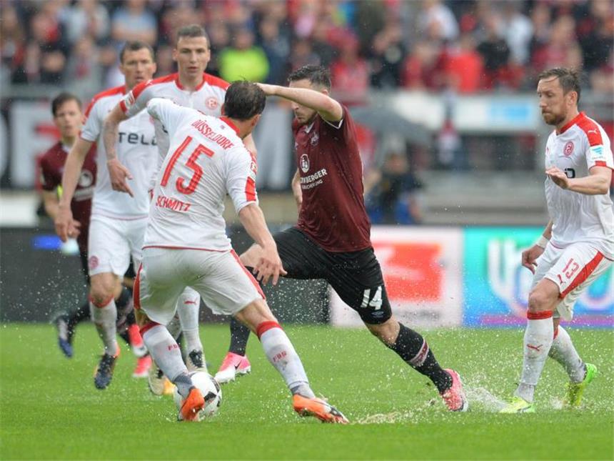 Düsseldorf mit wichtigem Sieg im Abstiegskampf Der Düsseldorfer Lukas Schmitz (l) im Zweikampf mit Nürnbergs Kevin Möhwald (M). Foto: Timm Schamberger
