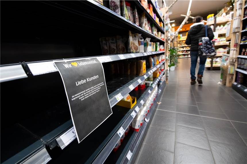 Leere Supermarktregale: Warum Speiseöle oftmals ausverkauft sind Eine Frau läuft durch einen Supermarkt. Im Vordergrund ist ein leeres Regal zu sehen, in dem normalerweise Mehl steht.