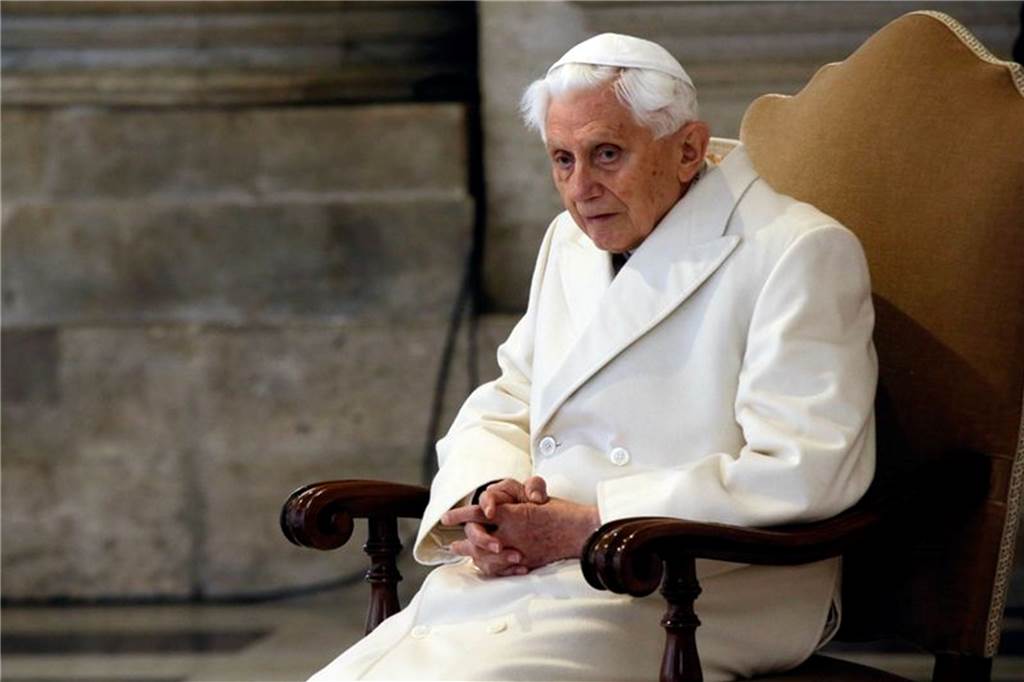 Der emeritierte Papst Benedikt XVI. sitzt in einem Stuhl.