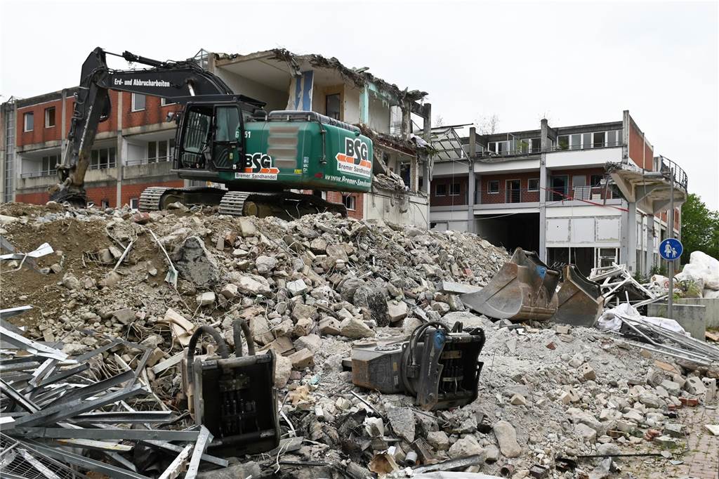 Der erste Flügel, vom Marktplatz aus gesehen links, ist bereits komplett abgerissen. Hier werden nur noch die Baustoffe getrennt. Auf der anderen Seite zerlegen die Bagger die einzelnen Wohnungen, Stockwerk für Stockwerk. Auch hier nähert man sich rasant der mittleren ehemaligen Einkaufsmeile.
