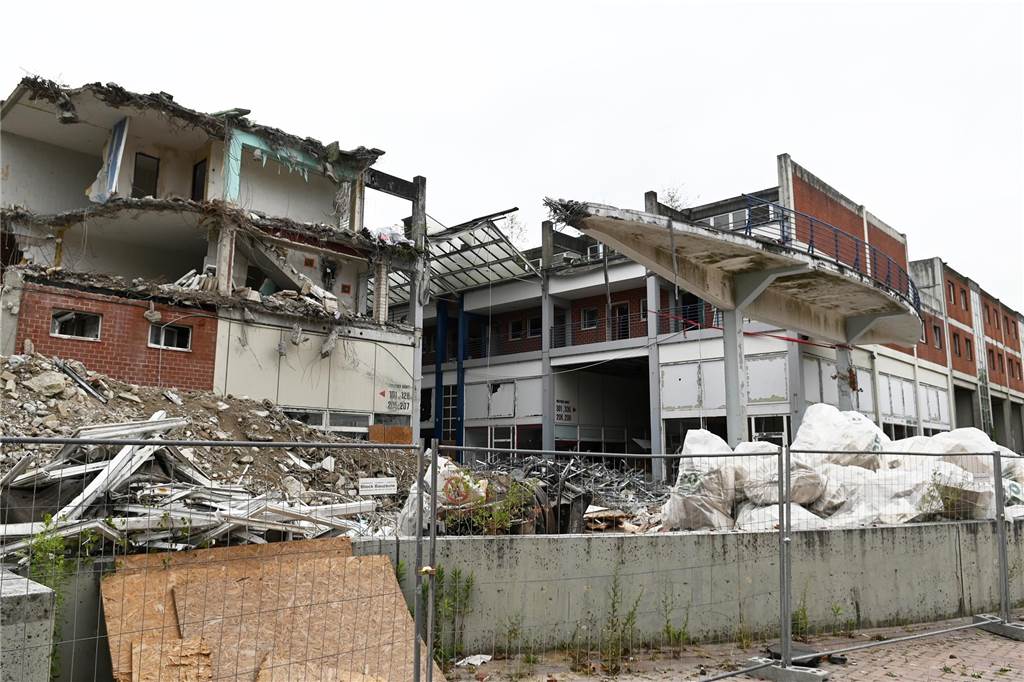 Der erste Flügel, vom Marktplatz aus gesehen links, ist bereits komplett abgerissen. Hier werden nur noch die Baustoffe getrennt. Auf der anderen Seite zerlegen die Bagger die einzelnen Wohnungen, Stockwerk für Stockwerk. Auch hier nähert man sich rasant der mittleren ehemaligen Einkaufsmeile.