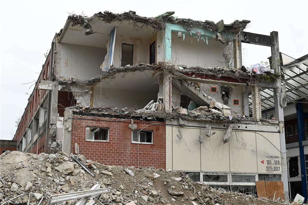Der erste Flügel, vom Marktplatz aus gesehen links, ist bereits komplett abgerissen. Hier werden nur noch die Baustoffe getrennt. Auf der anderen Seite zerlegen die Bagger die einzelnen Wohnungen, Stockwerk für Stockwerk. Auch hier nähert man sich rasant der mittleren ehemaligen Einkaufsmeile.