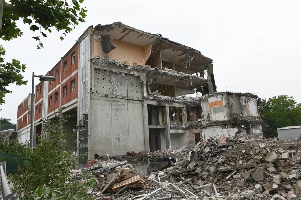 Der erste Flügel, vom Marktplatz aus gesehen links, ist bereits komplett abgerissen. Hier werden nur noch die Baustoffe getrennt. Auf der anderen Seite zerlegen die Bagger die einzelnen Wohnungen, Stockwerk für Stockwerk. Auch hier nähert man sich rasant der mittleren ehemaligen Einkaufsmeile.