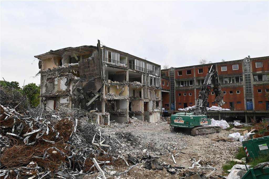 Der erste Flügel, vom Marktplatz aus gesehen links, ist bereits komplett abgerissen. Hier werden nur noch die Baustoffe getrennt. Auf der anderen Seite zerlegen die Bagger die einzelnen Wohnungen, Stockwerk für Stockwerk. Auch hier nähert man sich rasant der mittleren ehemaligen Einkaufsmeile.