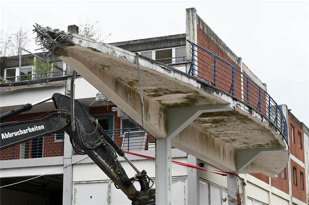 Der erste Flügel, vom Marktplatz aus gesehen links, ist bereits komplett abgerissen. Hier werden nur noch die Baustoffe getrennt. Auf der anderen Seite zerlegen die Bagger die einzelnen Wohnungen, Stockwerk für Stockwerk. Auch hier nähert man sich rasant der mittleren ehemaligen Einkaufsmeile.
