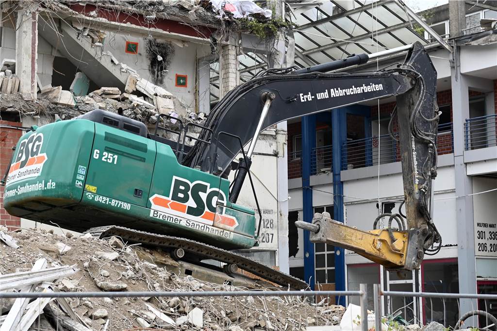 Der erste Flügel, vom Marktplatz aus gesehen links, ist bereits komplett abgerissen. Hier werden nur noch die Baustoffe getrennt. Auf der anderen Seite zerlegen die Bagger die einzelnen Wohnungen, Stockwerk für Stockwerk. Auch hier nähert man sich rasant der mittleren ehemaligen Einkaufsmeile.