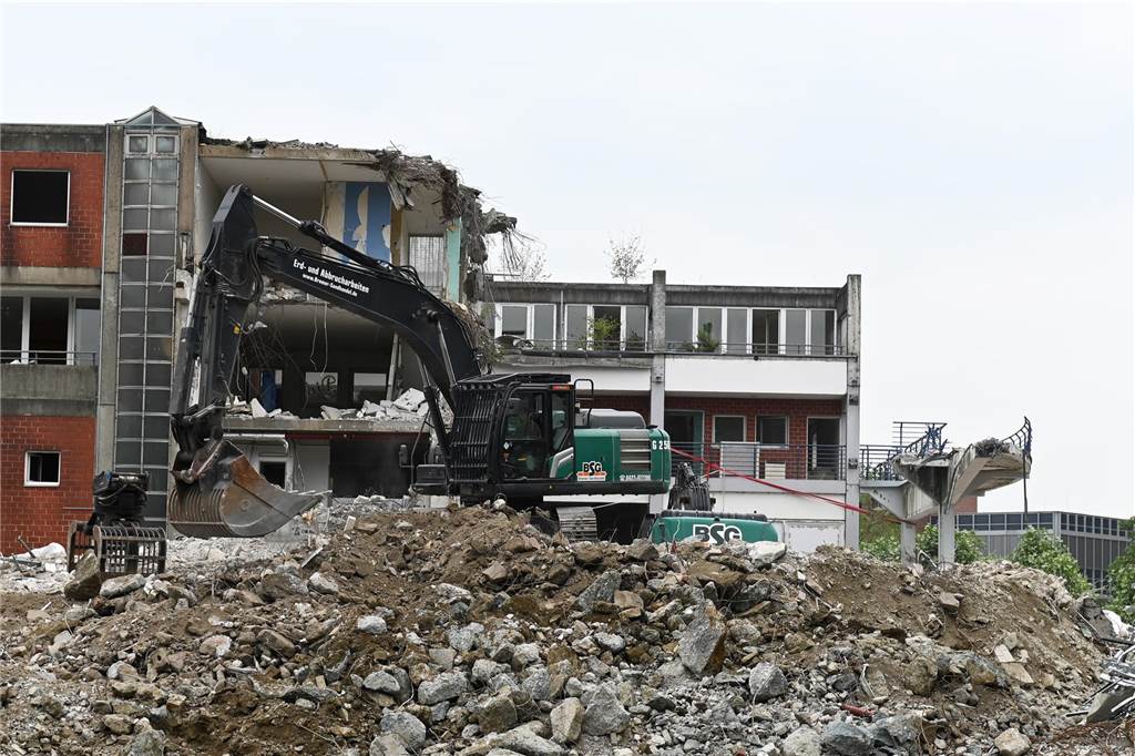 Der erste Flügel, vom Marktplatz aus gesehen links, ist bereits komplett abgerissen. Hier werden nur noch die Baustoffe getrennt. Auf der anderen Seite zerlegen die Bagger die einzelnen Wohnungen, Stockwerk für Stockwerk. Auch hier nähert man sich rasant der mittleren ehemaligen Einkaufsmeile.