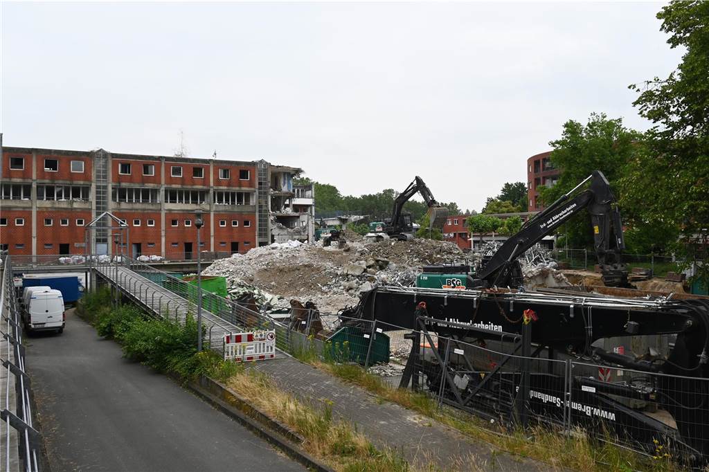 Der erste Flügel, vom Marktplatz aus gesehen links, ist bereits komplett abgerissen. Hier werden nur noch die Baustoffe getrennt. Auf der anderen Seite zerlegen die Bagger die einzelnen Wohnungen, Stockwerk für Stockwerk. Auch hier nähert man sich rasant der mittleren ehemaligen Einkaufsmeile.