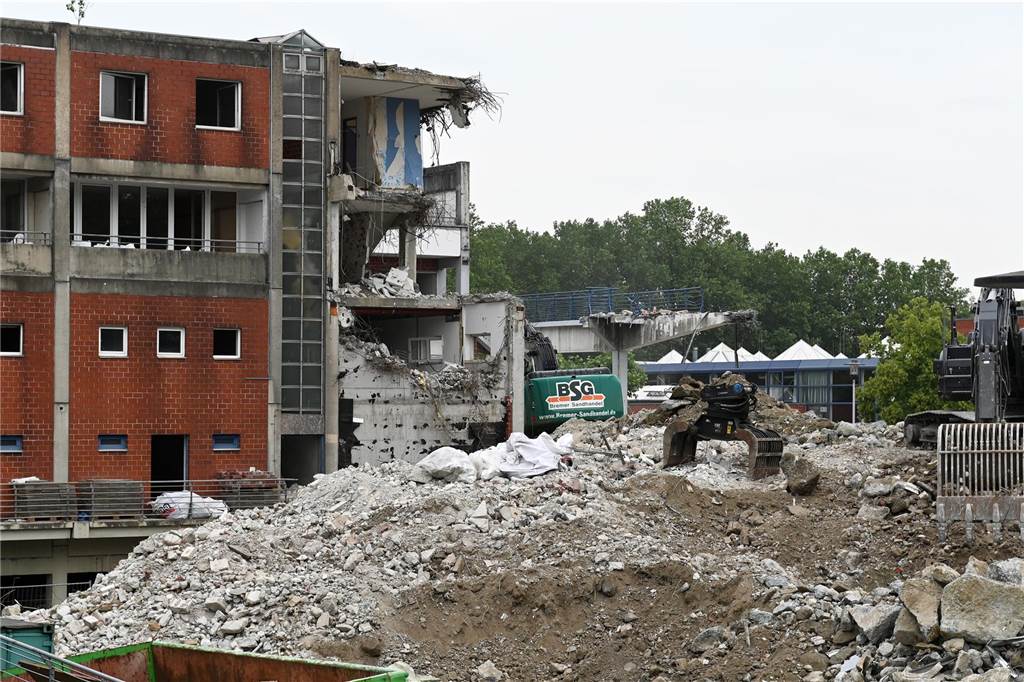 Der erste Flügel, vom Marktplatz aus gesehen links, ist bereits komplett abgerissen. Hier werden nur noch die Baustoffe getrennt. Auf der anderen Seite zerlegen die Bagger die einzelnen Wohnungen, Stockwerk für Stockwerk. Auch hier nähert man sich rasant der mittleren ehemaligen Einkaufsmeile.