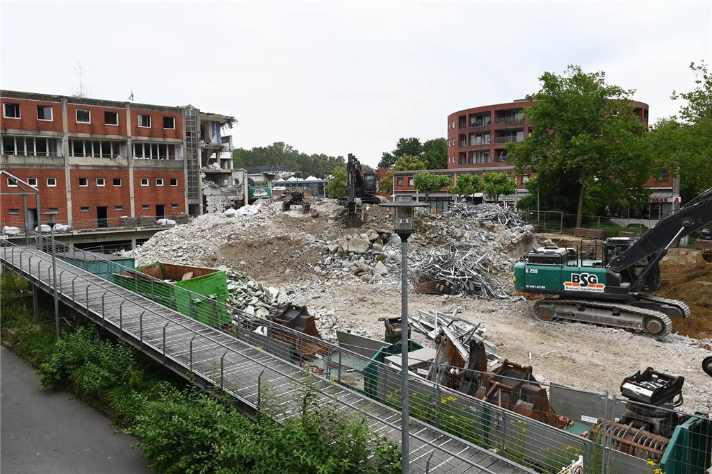 Der erste Flügel, vom Marktplatz aus gesehen links, ist bereits komplett abgerissen. Hier werden nur noch die Baustoffe getrennt. Auf der anderen Seite zerlegen die Bagger die einzelnen Wohnungen, Stockwerk für Stockwerk. Auch hier nähert man sich rasant der mittleren ehemaligen Einkaufsmeile.