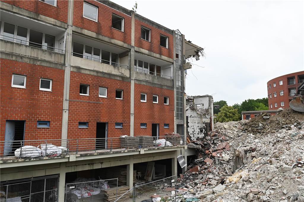 Der erste Flügel, vom Marktplatz aus gesehen links, ist bereits komplett abgerissen. Hier werden nur noch die Baustoffe getrennt. Auf der anderen Seite zerlegen die Bagger die einzelnen Wohnungen, Stockwerk für Stockwerk. Auch hier nähert man sich rasant der mittleren ehemaligen Einkaufsmeile.