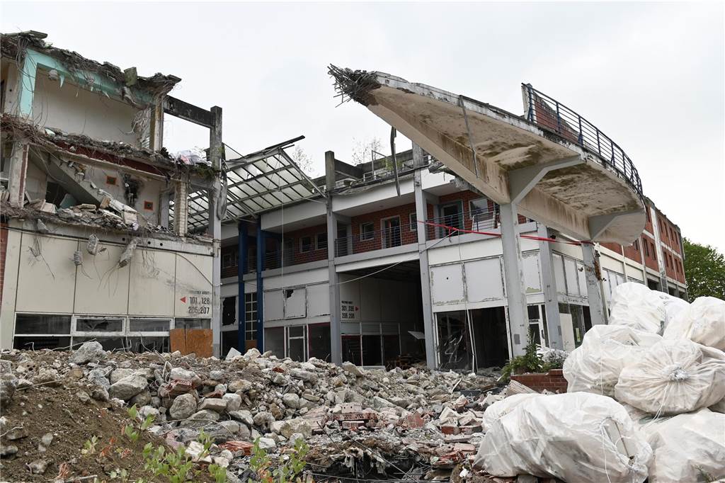 Der erste Flügel, vom Marktplatz aus gesehen links, ist bereits komplett abgerissen. Hier werden nur noch die Baustoffe getrennt. Auf der anderen Seite zerlegen die Bagger die einzelnen Wohnungen, Stockwerk für Stockwerk. Auch hier nähert man sich rasant der mittleren ehemaligen Einkaufsmeile.