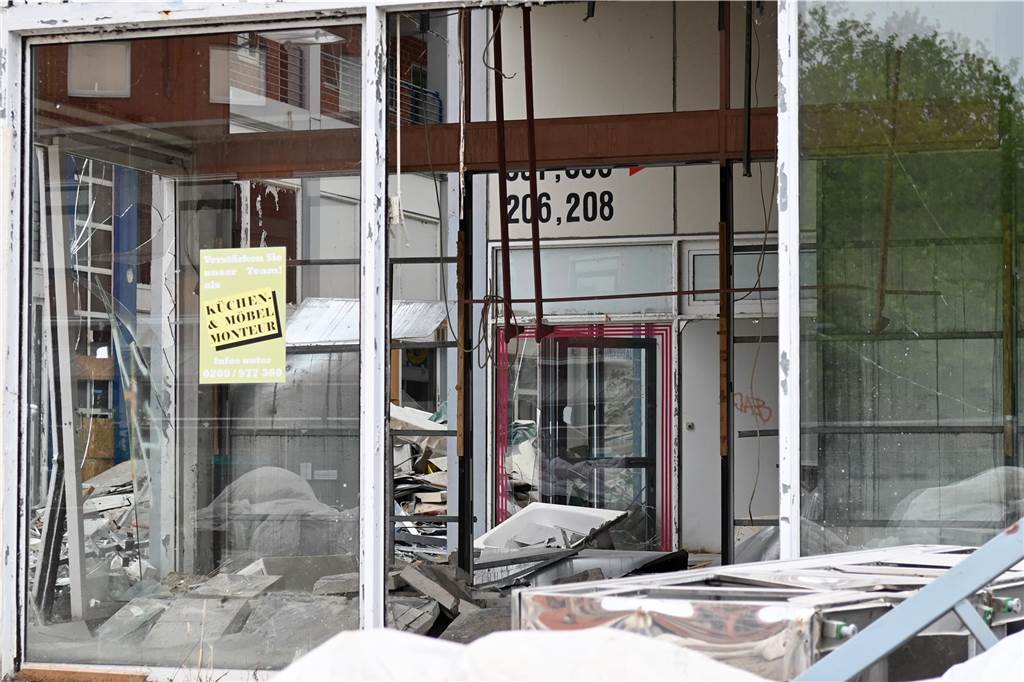 Der erste Flügel, vom Marktplatz aus gesehen links, ist bereits komplett abgerissen. Hier werden nur noch die Baustoffe getrennt. Auf der anderen Seite zerlegen die Bagger die einzelnen Wohnungen, Stockwerk für Stockwerk. Auch hier nähert man sich rasant der mittleren ehemaligen Einkaufsmeile.